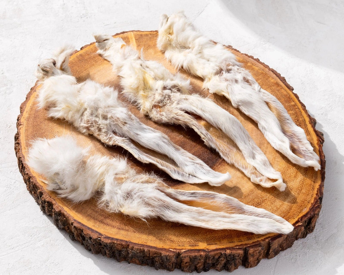 Gedroogde konijnenoren met vacht op een houten plank – natuurlijke hondensnack